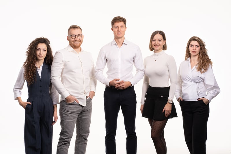 The five members of the MMCG team standing shoulder to shoulder in white and navy business dress against a plain white background.
