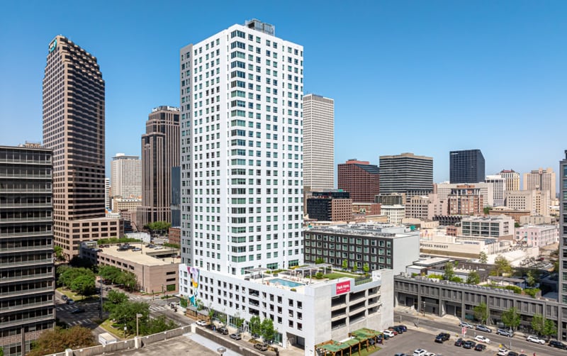 A contemporary mixed-use high-rise in downtown New Orleans illustrates the scale of post-Katrina reinvestment in the Gulf Coast's most wind-exposed metropolitan core. Structures of this profile, typically 20 stories or greater with integrated parking podiums, must satisfy stringent wind-load design criteria under ASCE 7-22, reflecting sustained hurricane exposure that FEMA classifies within a 150+ mph basic wind speed zone. Hurricane Katrina (2005) inflicted over $125 billion in total damages across the Gulf region and fundamentally reshaped building code enforcement, insurance underwriting standards, and lender risk modeling for commercial real estate in coastal Louisiana. For feasibility analysts, the convergence of tornado-alley proximity, Gulf hurricane corridors, and urban density in markets like New Orleans represents one of the most complex wind-hazard profiles in the continental United States.